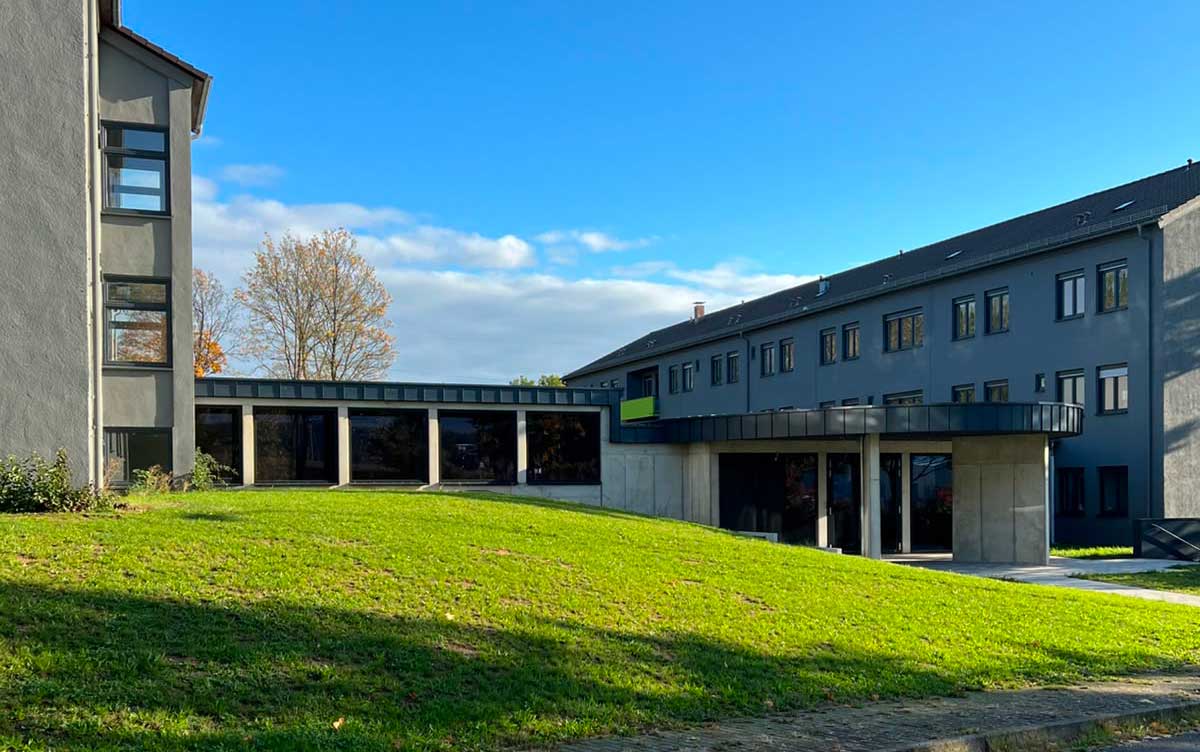 Außenansicht des IFA Germany Fußballcampus Ebern mit den beiden Hauptgebäuden und dem Pavillon in der Mitte